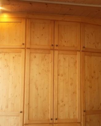 armadio in abete spizzato con varie ante e ripiani