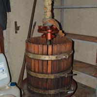 Torchio per uva con bottiglioni e damigiane