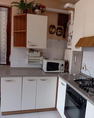 cucina con sedie mensole e divano