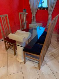 Tavolo in cristallo con colonne in pietra