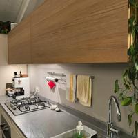 Cucina lineare bianco laccato, quarzite e rovere