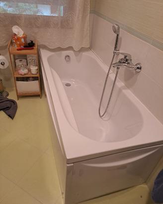 vasca da bagno con pannelli e miscelatore