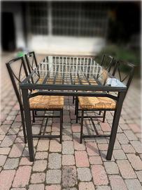 Tavolo in ferro e vetro con sedie in paglia