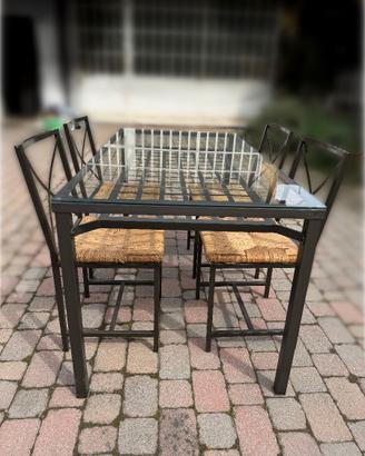 Tavolo in ferro e vetro con sedie in paglia