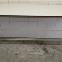 Tavolo in acciaio con base in formica bianca