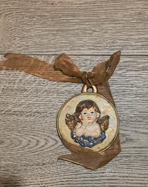 Medaglione in terracotta con un angelo dorato. Un