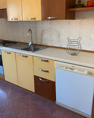 Cucina completa di colore legno e giallo caldo