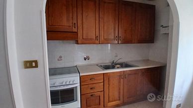 Cucina con cucina a gas e frigo con piccolo frizer