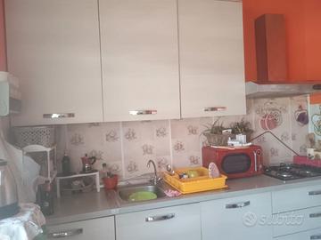 Cucina completa di tavolo ed elettrodomestici.