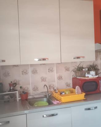 Cucina completa di tavolo ed elettrodomestici.