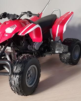 Quad giocattolo rosso radiocomandato.
