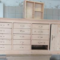 Bancone in legno da negozio con cassettiere.