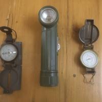 Una torcia e due bussole militari