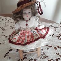 Bambolina in ceramica su sedia.  Vintage 