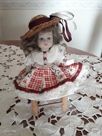 Bambolina in ceramica su sedia.  Vintage 