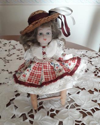 Bambolina in ceramica su sedia.  Vintage 