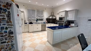 Cucina bianca con penisola e elettrodomestici