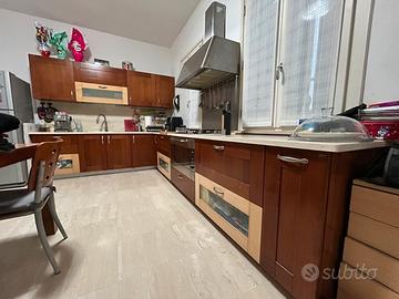 Cucina ad angolo, ante in ciliegio, top in marmo