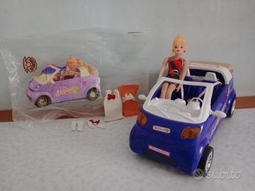 Bambolina alla guida di un'automobile & abitini