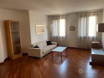 Divano beige con vetrina portaoggetti