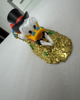 Zio paperone che si tuffa nelle monete d’oro