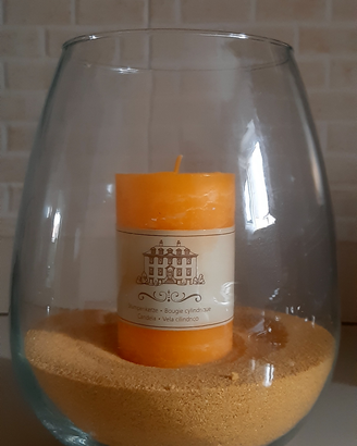 Vaso in vetro con sabbia e candela all'interno