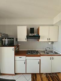 cucina + tavolo + microonde + tv + mobili + forno