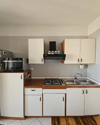 cucina + tavolo + microonde + tv + mobili + forno