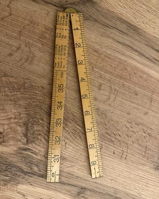 Vecchio metro pieghevole inglese in legno e ottone