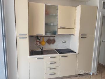 Cucina, tavolo con sedie e soggiorno 
