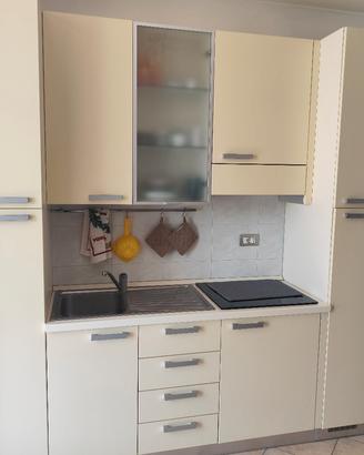 Cucina, tavolo con sedie e soggiorno 