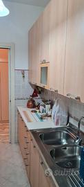 cucina con macchina del gas e tavolo con sedie