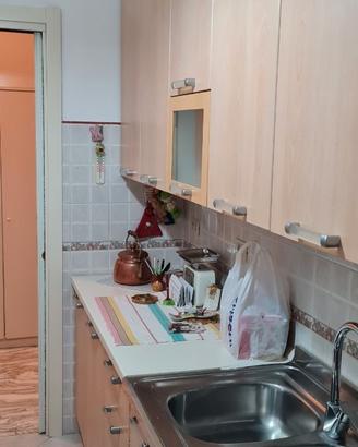 cucina con macchina del gas e tavolo con sedie