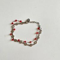 Braccialetto color argento con perline rosse