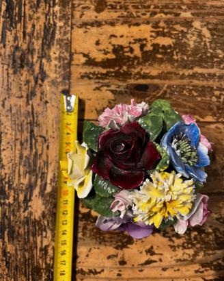 Bouquet di fiori in ceramica su base bianca