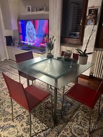 Tavolo in vetro con sedie in pelle e tavolino