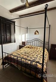 Letto a baldacchino matrimoniale.