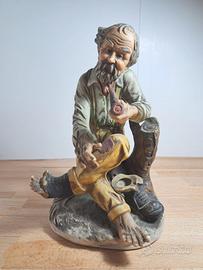 Vecchio con pipa seduto su tronco