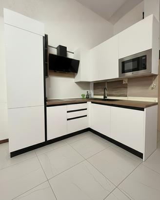 Cucina angolare bianca co elettrodomestici moderna