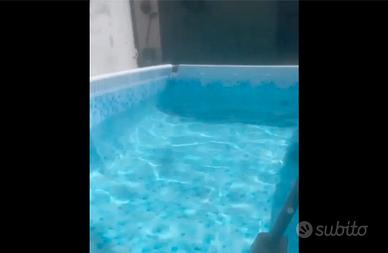 Piscina con ombrellone da giardino e prato finto