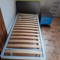 Letto con doghe in legno e comodino con ruote