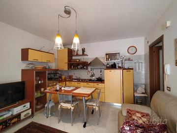 cucina con tavolo e 4 sedie, divano a due posti