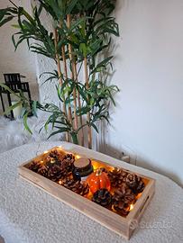 “Centrotavola autunnale con pigne, luci e decoraz