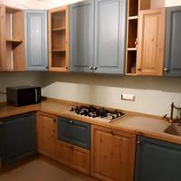 Cucina con elettrodomestici, tavolo e sedie