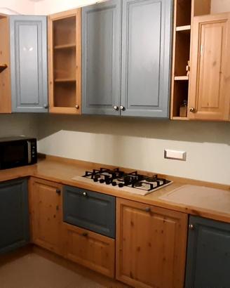 Cucina con elettrodomestici, tavolo e sedie
