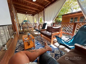 Casetta in legno con veranda e roulotte