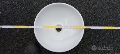 Lavabo bagno in ceramica e lampada sopra lavabo