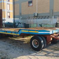 Rimorchio pianale con rampe macchina operatrice