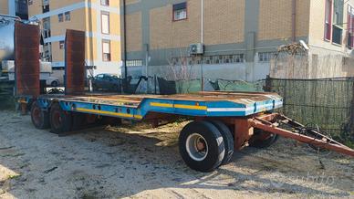 Rimorchio pianale con rampe macchina operatrice