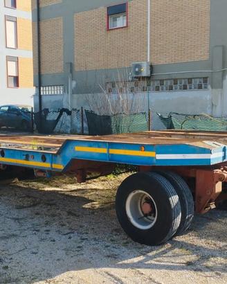 Rimorchio pianale con rampe macchina operatrice